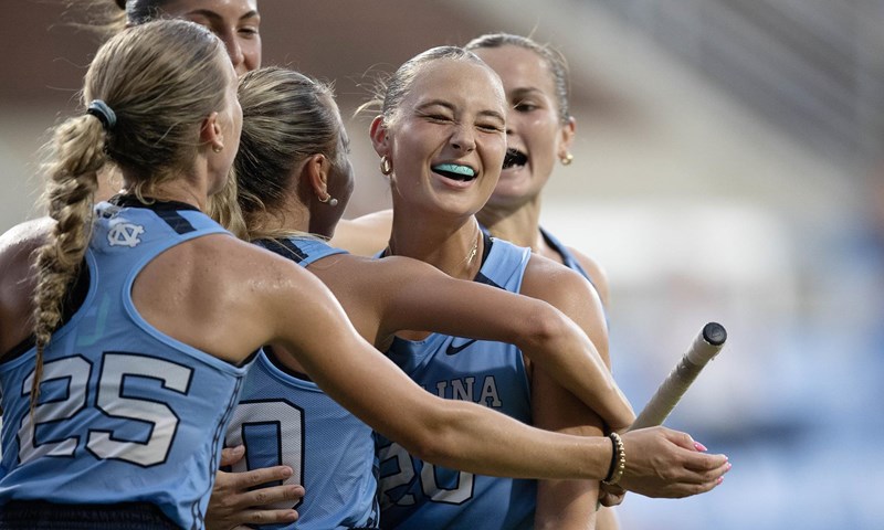 North Carolina field hockey players celebrate together during a game.