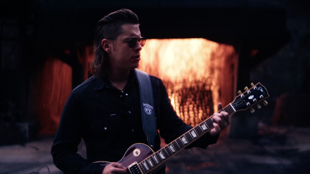 Redferrin holding a Gibson Les Paul guitar in front of firelight in the "Don't Slow Down" visualizer (photo: Warner Records Nashville)