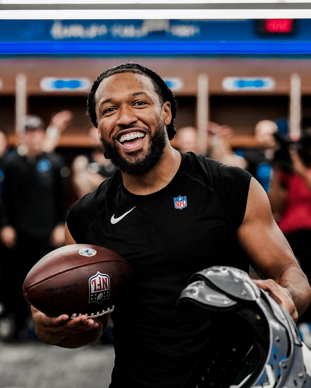 Detroit Lions player celebrates in the locker room with the game ball after the win over the Green Bay Packers