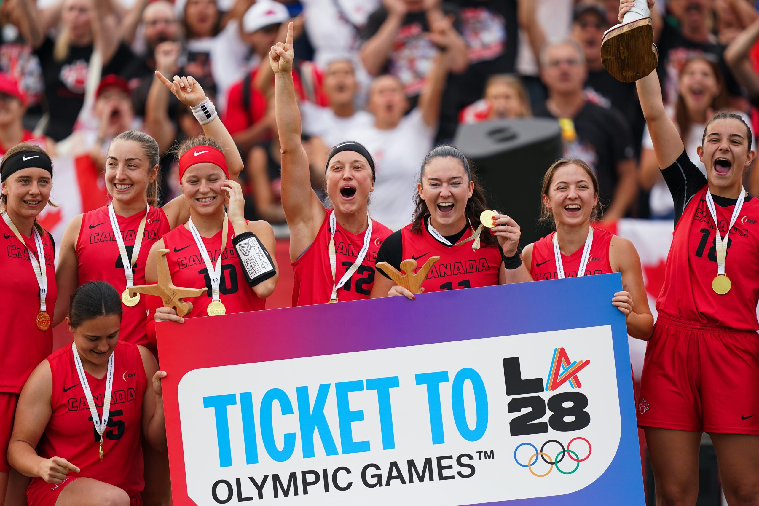 Canada celebrates with its 'Ticket to LA28' board after winning the IFAF World Championship.