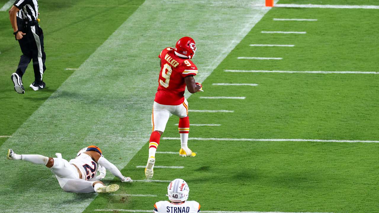 Kansas City Chiefs running back Kenneth Walker III breaks away from Denver Broncos defenders.