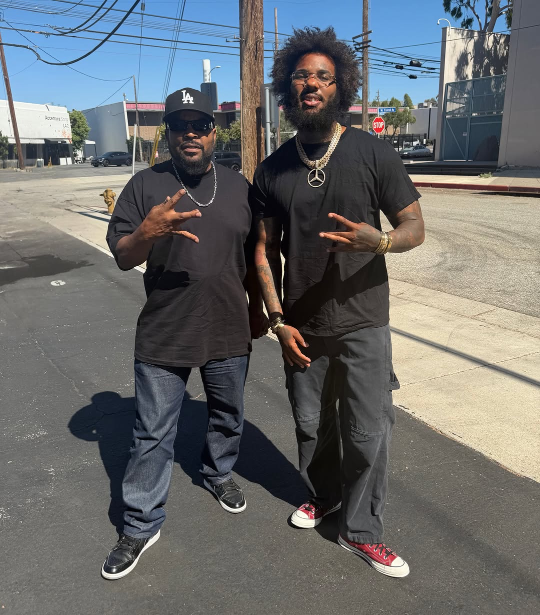 The Game stands with Ice Cube on a Los Angeles street, both dressed in black.
