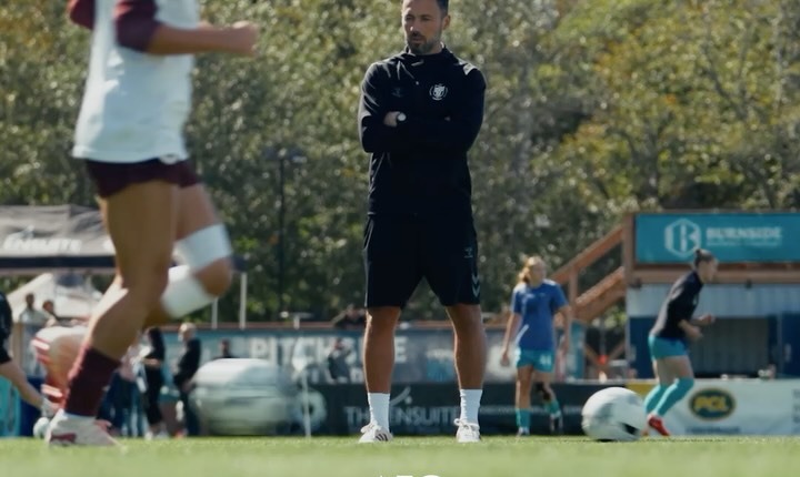 AFC Toronto head coach Marko Milanovic standing on the pitch with his arms crossed as his players train around him