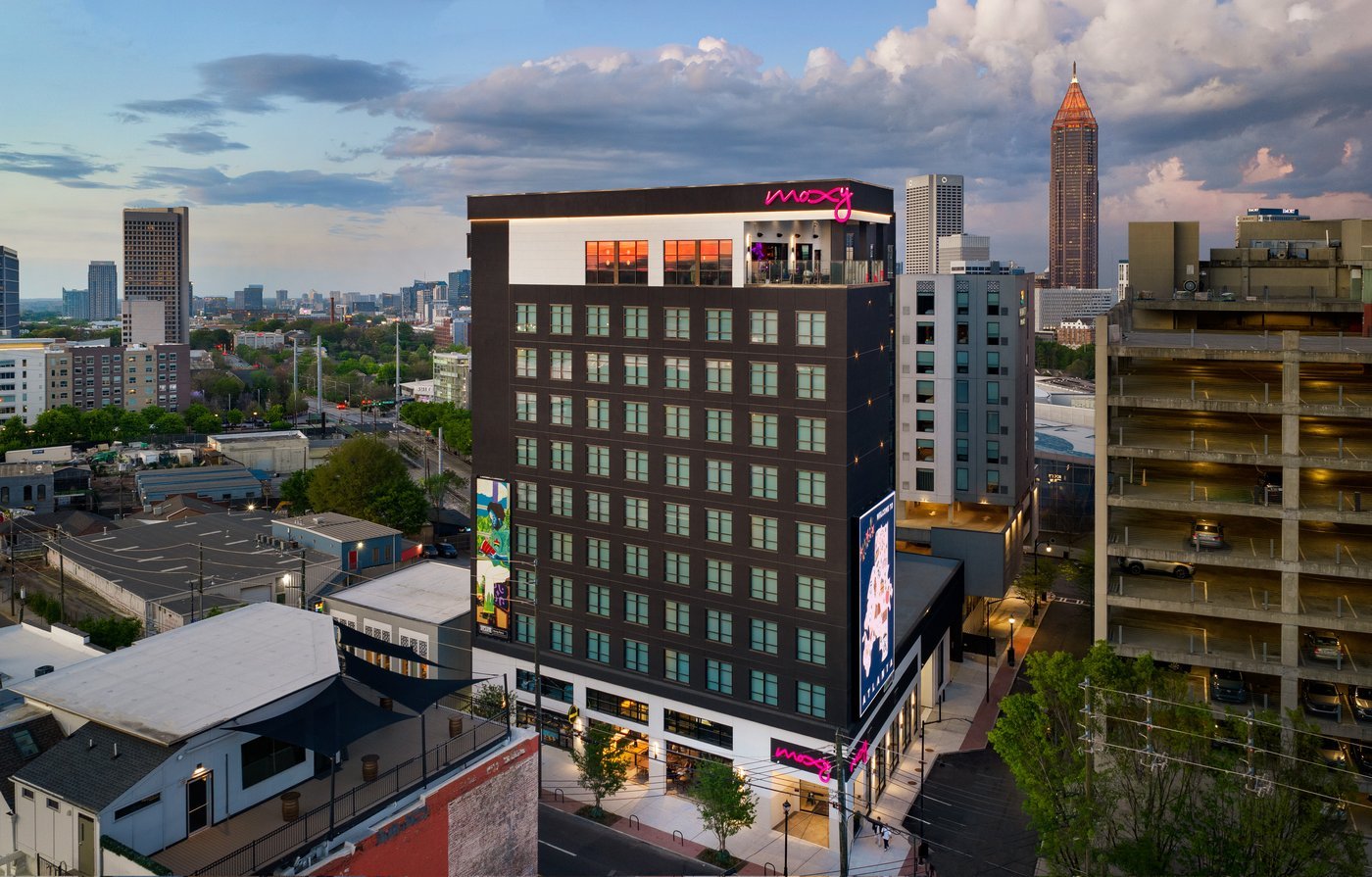 Moxy Atlanta Downtown at dusk, with the Atlanta skyline behind it