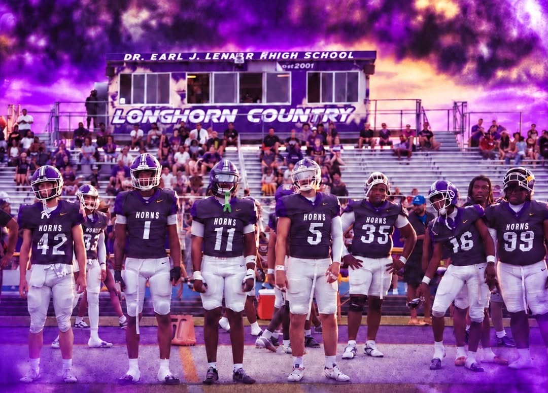 Lennard Longhorns players in purple jerseys and white pants lined up on the field in front of the home stands