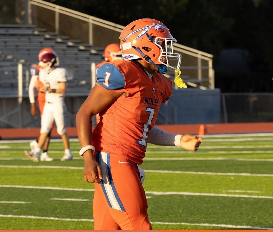 Southeast Seminoles player in an orange uniform and orange helmet on the field before a game
